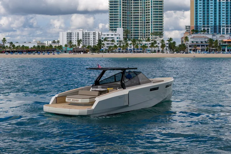 Slide: The Image of 2023 Evo Yachts R4 WA cruising near a coastal city skyline. - 2