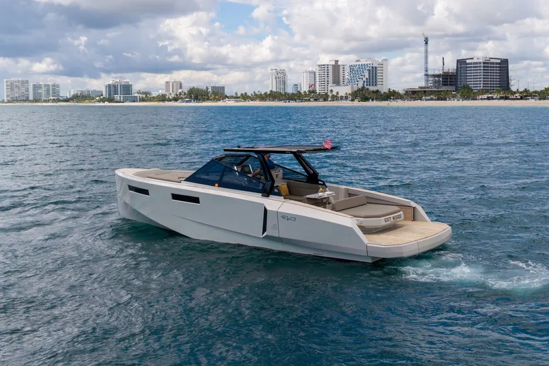 The Image of 2023 Evo Yachts R4 WA cruising on the ocean near a city skyline. - 1