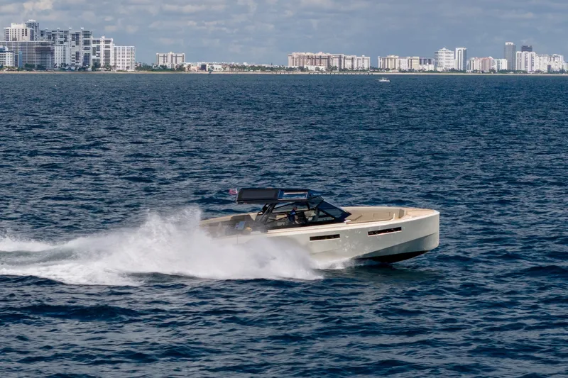 Slide: The Image of 2023 Evo Yachts R4 WA cruising on open water near city skyline. - 22