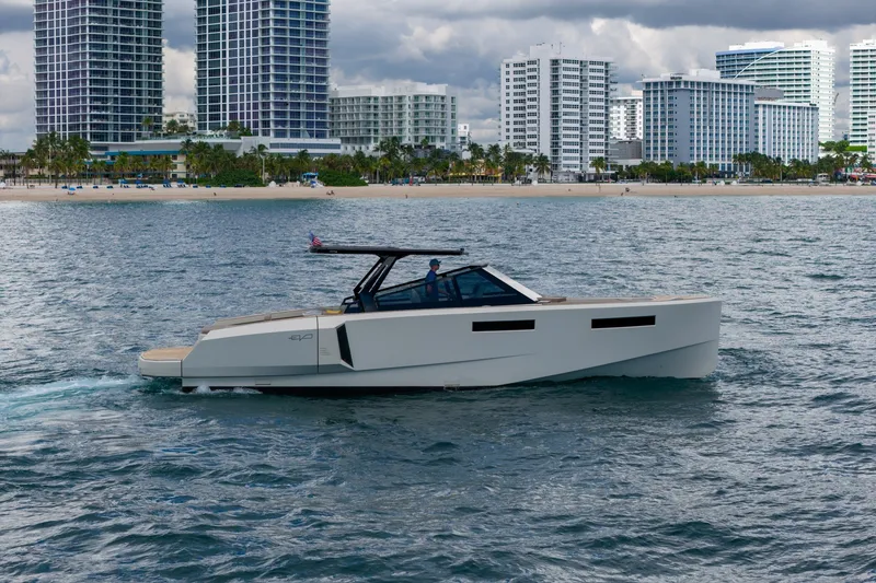 Slide: The Image of 2023 Evo Yachts R4 WA cruising near a city skyline and beach. - 3
