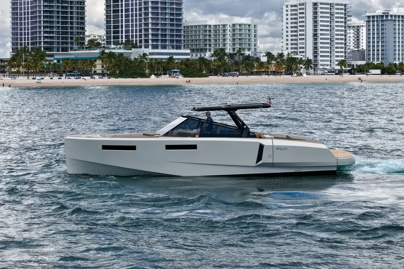 Slide: The Image of 2023 Evo Yachts R4 WA cruising near a city shoreline with modern buildings. - 5