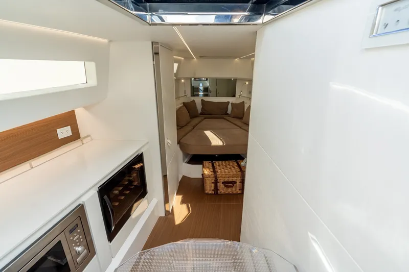 Slide: The Image of Interior of 2023 Evo Yachts R4 WA, featuring modern kitchen and cozy sleeping area. - 26