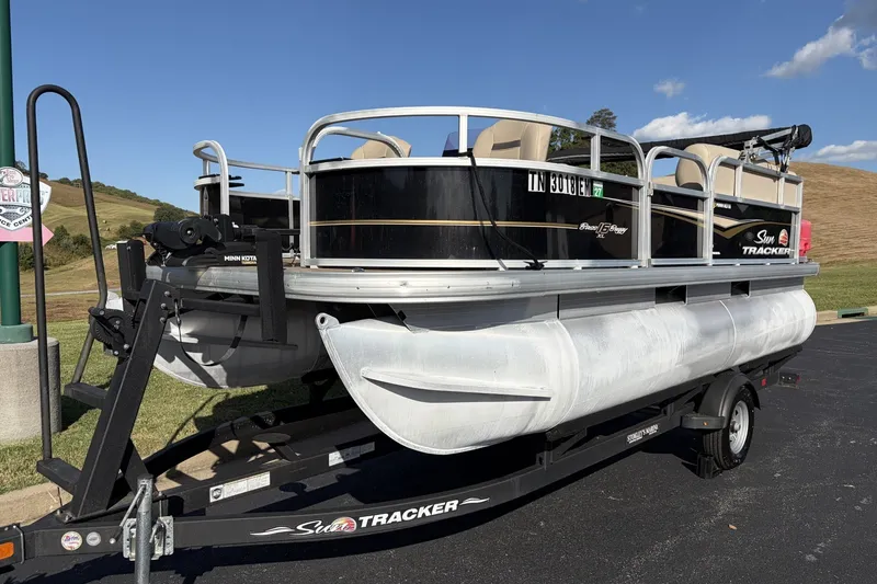 The Image of 2021 Sun Tracker Bass Buggy 16 DLX pontoon boat on trailer, parked outdoors. - 0