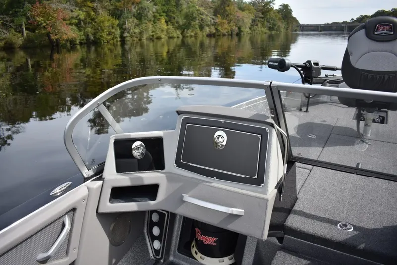 Slide: The Image of 2023 Ranger 622FS Pro boat interior on a calm river with lush greenery. - 16