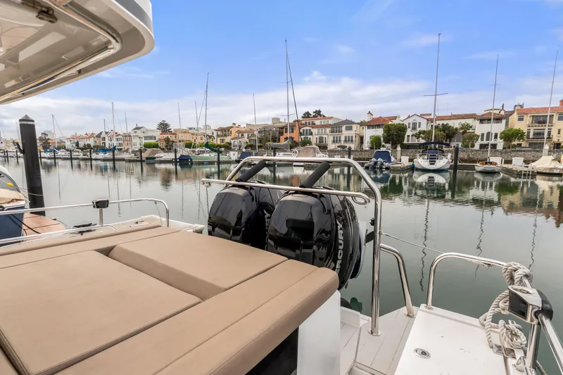 Slide: The Image of 2019 Axopar 37 Cabin boat docked in a scenic marina with waterfront homes. - 16