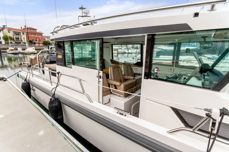 Slide: The Image of 2019 Axopar 37 Cabin boat docked at marina, showcasing sleek design and interior seating. - 19
