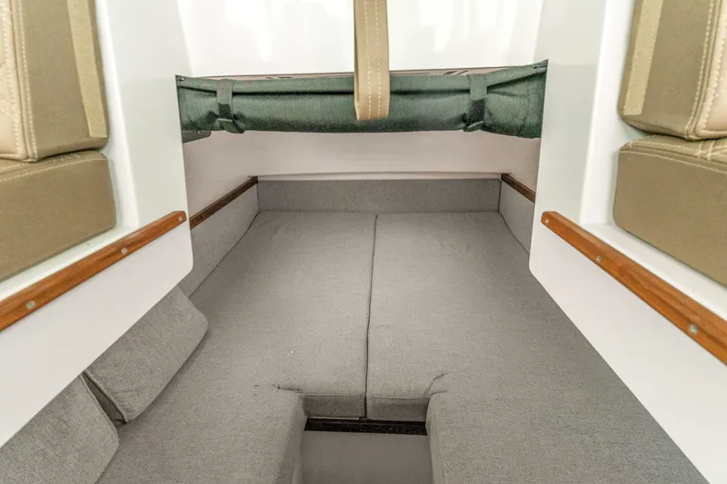 Slide: The Image of Interior cabin of 2019 Axopar 37 Cabin boat with gray seating and wood accents. - 14