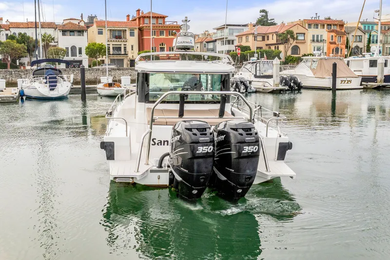 Slide: The Image of 2019 Axopar 37 Cabin boat with twin Mercury 350 engines docked in a marina. - 24