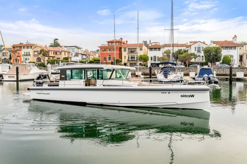 The Image of A 2019 Axopar 37 Cabin boat is docked in a picturesque harbor setting. - 0