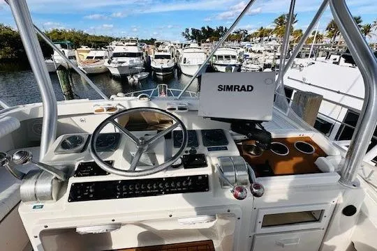 Slide: The Image of 2001 Luhrs 40 Convertible yacht helm with Simrad navigation, docked among other boats. - 10