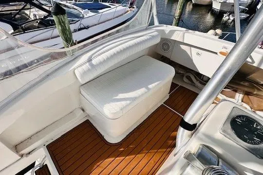 Slide: The Image of 2001 Luhrs 40 Convertible boat interior with cushioned seating and wooden deck. - 12