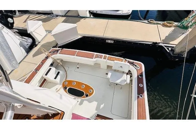 Slide: The Image of 2001 Luhrs 40 Convertible boat docked, featuring spacious deck and fishing chair. - 15