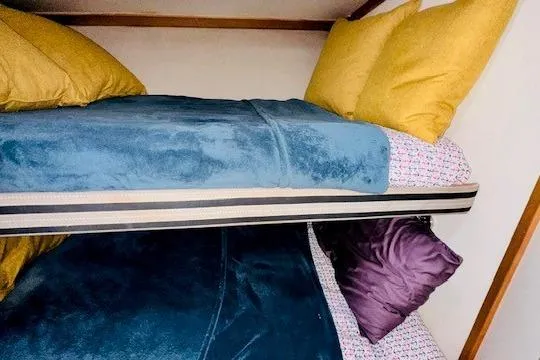 Slide: The Image of Bunk beds with colorful bedding in a 2001 Luhrs 40 Convertible boat cabin. - 9