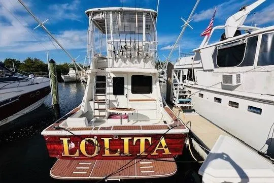Slide: The Image of 2001 Luhrs 40 Convertible boat named "Lolita" docked at a marina. - 16