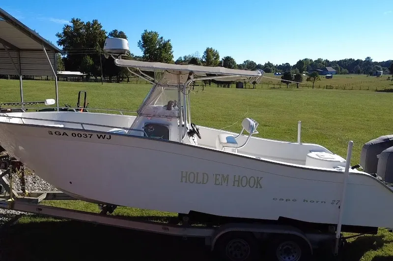 Slide: The Image of 2000 Cape Horn 27XS boat on trailer in grassy area, labeled "Hold 'Em Hook." - 11