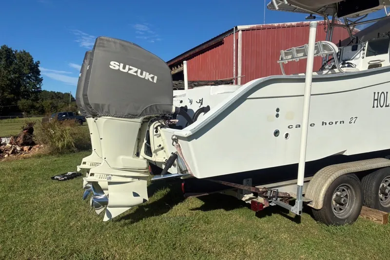 Slide: The Image of Cape Horn 27XS boat with Suzuki outboard motor on trailer, grassy yard background. - 17