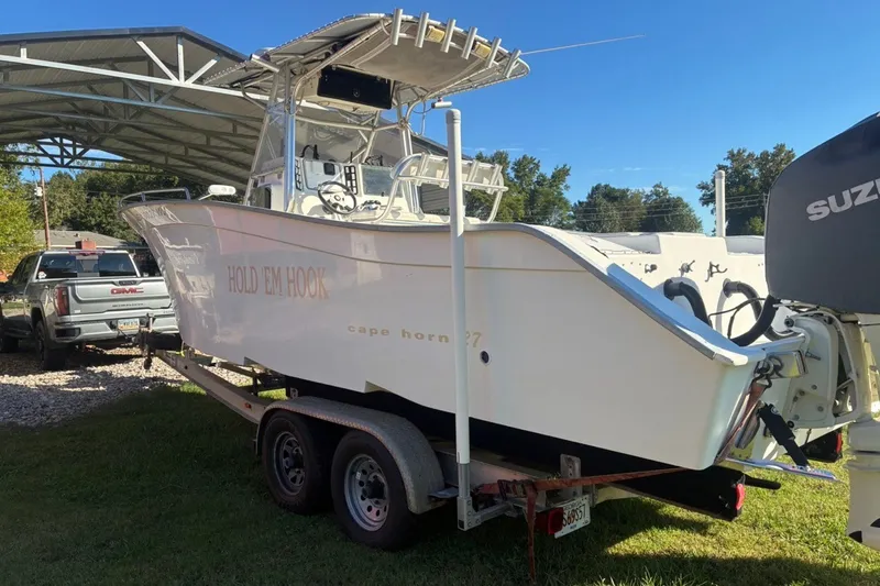 Slide: The Image of 2000 Cape Horn 27XS boat on trailer, parked outdoors near a covered area. - 10