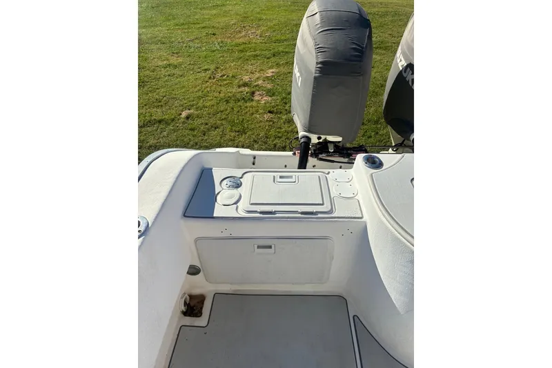 Slide: The Image of 2000 Cape Horn 27XS boat deck with covered outboard motors, on grassy background. - 21