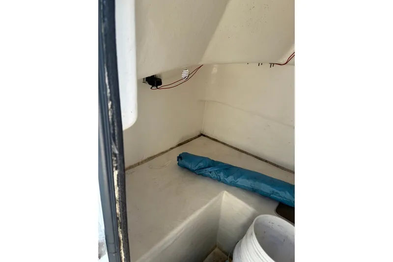 Slide: The Image of Interior of a 2000 Cape Horn 27XS boat, featuring storage space and wiring. - 33