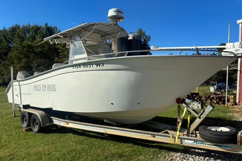 Slide: The Image of 2000 Cape Horn 27XS boat on trailer, labeled "HOLD EM HOOK," parked on grass. - 1