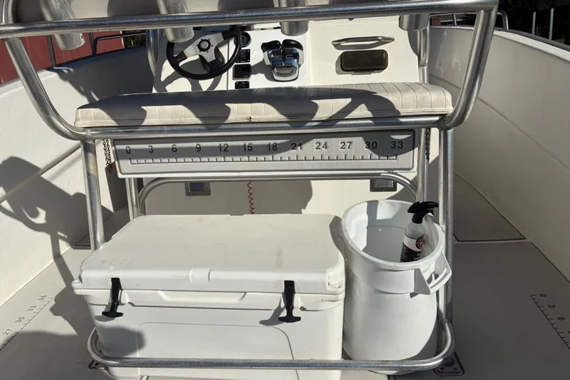 Slide: The Image of Center console of a 2000 Cape Horn 27XS boat with cooler and cleaning supplies. - 46