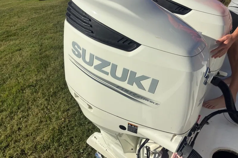 Slide: The Image of Suzuki outboard motor on a 2000 Cape Horn 27XS boat, parked on grass. - 19