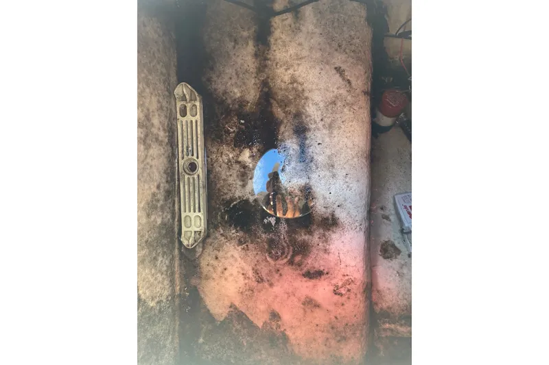 Slide: The Image of Dirty interior of a 2000 Cape Horn 27XS boat with visible components. - 59