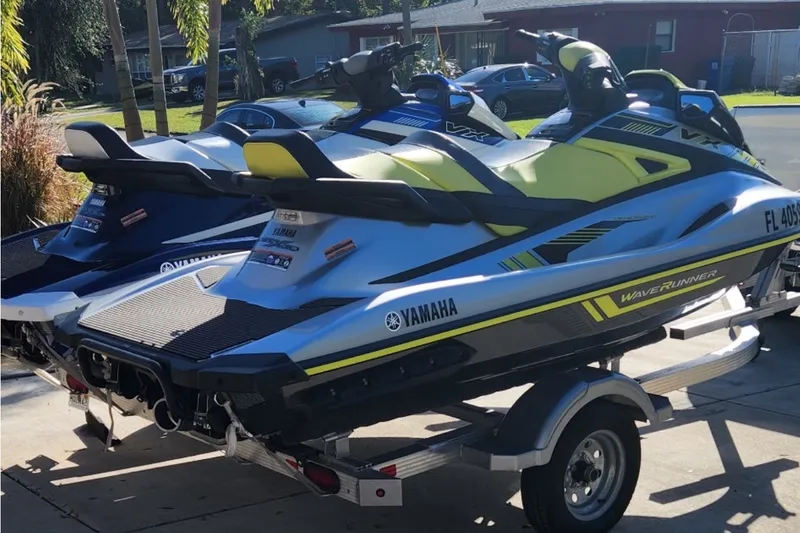 The Image of 2020 Yamaha WaveRunner VX Cruiser HO jet skis on a trailer in a driveway. - 0