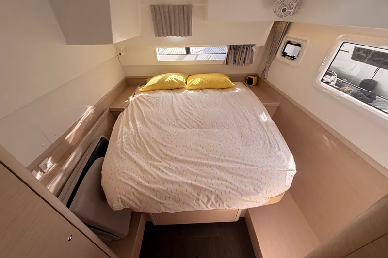 Slide: The Image of Cozy bedroom interior of 2020 Lagoon 42 catamaran with double bed and windows. - 63