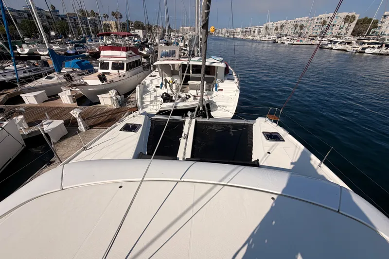 Slide: The Image of 2020 Lagoon 42 catamaran docked in a marina, surrounded by various boats. - 43