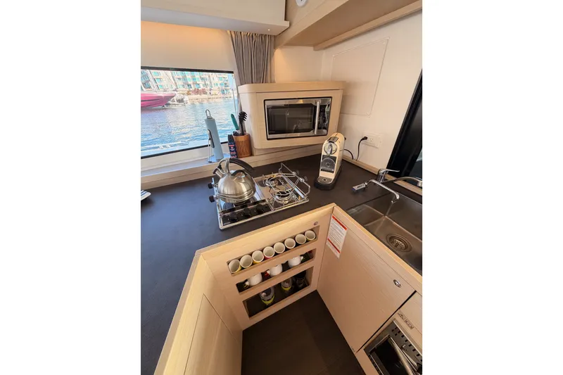 Slide: The Image of Modern kitchen interior on 2020 Lagoon 42 yacht with stove, sink, and window view. - 54