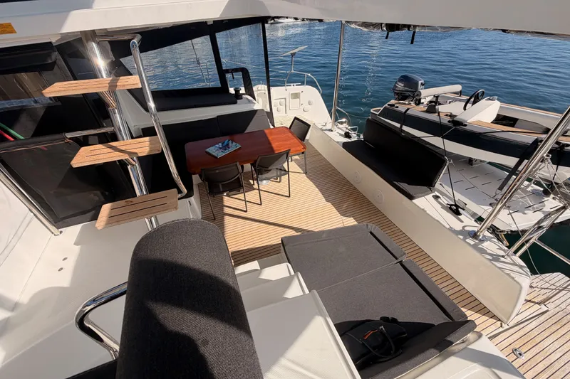 Slide: The Image of Luxurious 2020 Lagoon 42 yacht interior with seating, table, and helm, docked on calm water. - 47