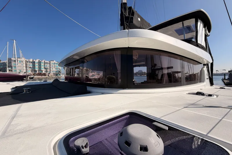 Slide: The Image of 2020 Lagoon 42 catamaran docked, showcasing sleek design and modern architecture against a marina backdrop. - 4
