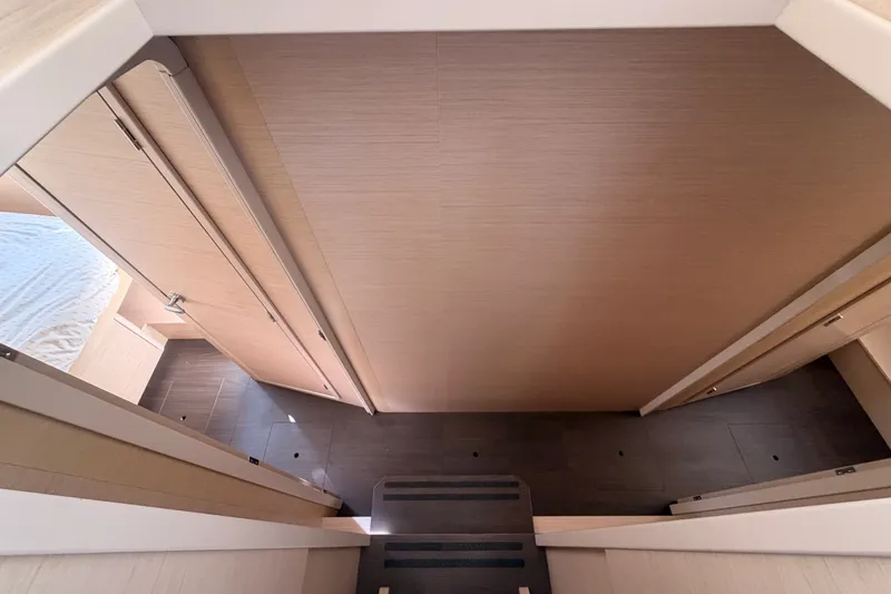 Slide: The Image of Interior view of a 2020 Lagoon 42 yacht, featuring modern wooden cabinetry and flooring. - 60