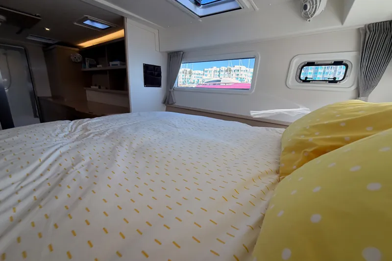 Slide: The Image of Interior of 2020 Lagoon 42 yacht cabin with cozy bed and window view. - 89