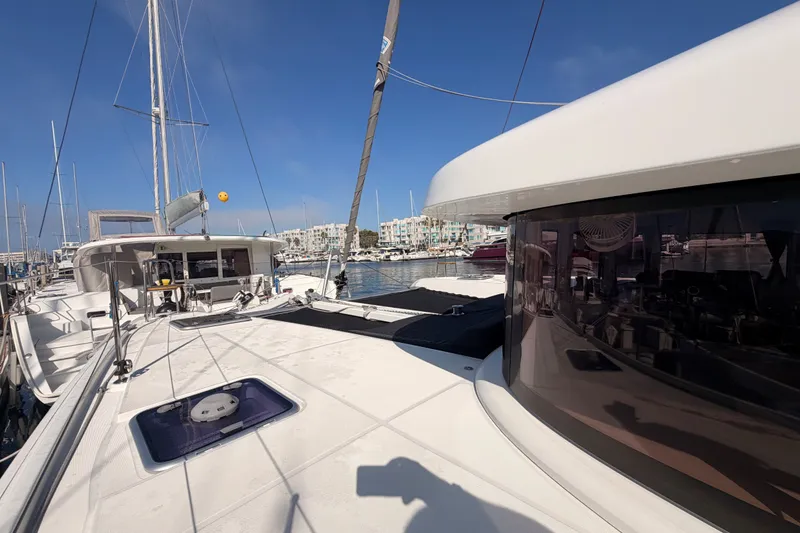 Slide: The Image of 2020 Lagoon 42 catamaran docked at marina under clear blue sky. - 14