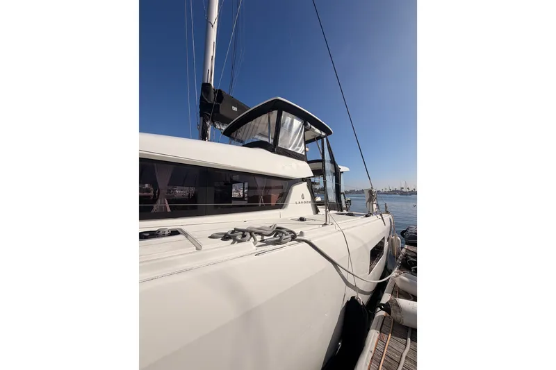 Slide: The Image of 2020 Lagoon 42 catamaran docked, showcasing sleek design and modern features under clear blue sky. - 5