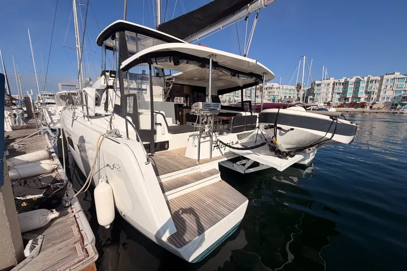 Slide: The Image of 2020 Lagoon 42 catamaran docked at marina with clear blue sky. - 7