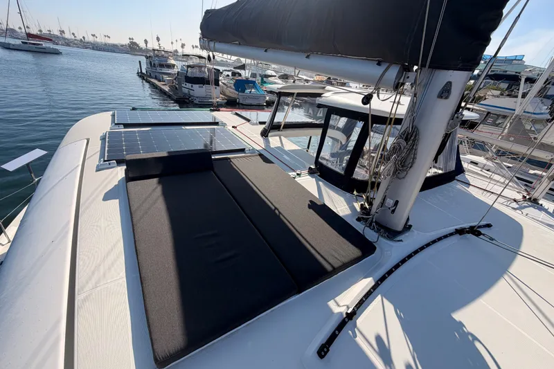 Slide: The Image of 2020 Lagoon 42 catamaran with solar panels docked in a marina. - 44