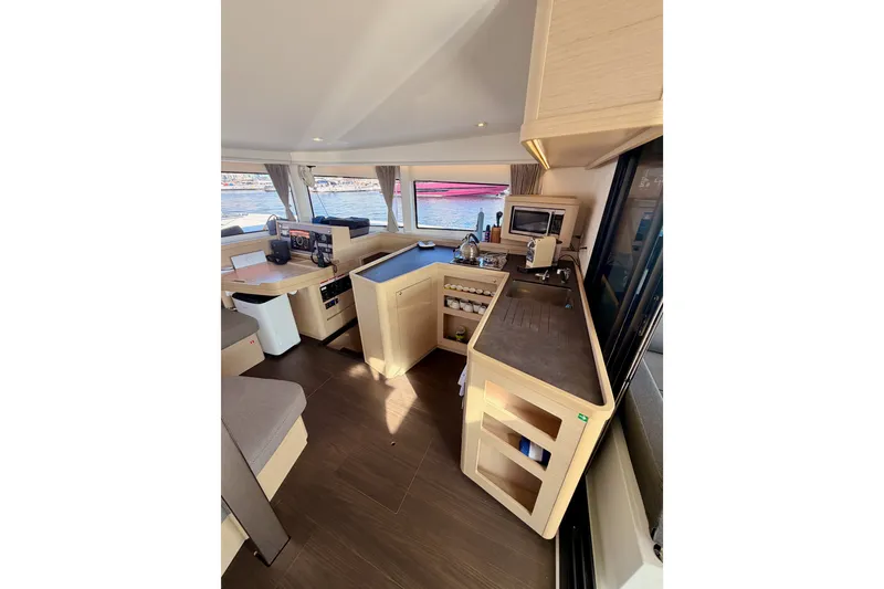 Slide: The Image of Interior of 2020 Lagoon 42 catamaran featuring modern kitchen and dining area with scenic views. - 52