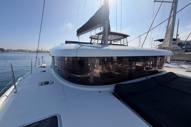 Slide: The Image of 2020 Lagoon 42 catamaran docked in a marina under clear blue skies. - 22