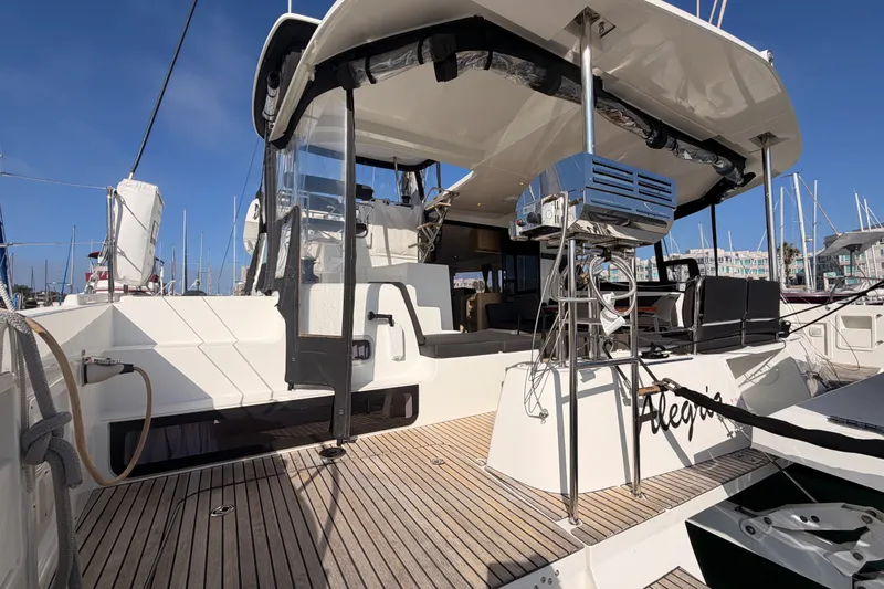 Slide: The Image of 2020 Lagoon 42 catamaran with spacious deck and modern amenities in marina setting. - 10
