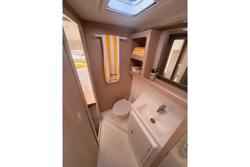 Slide: The Image of Modern bathroom in 2020 Lagoon 42 yacht with sink, toilet, and storage shelves. - 68