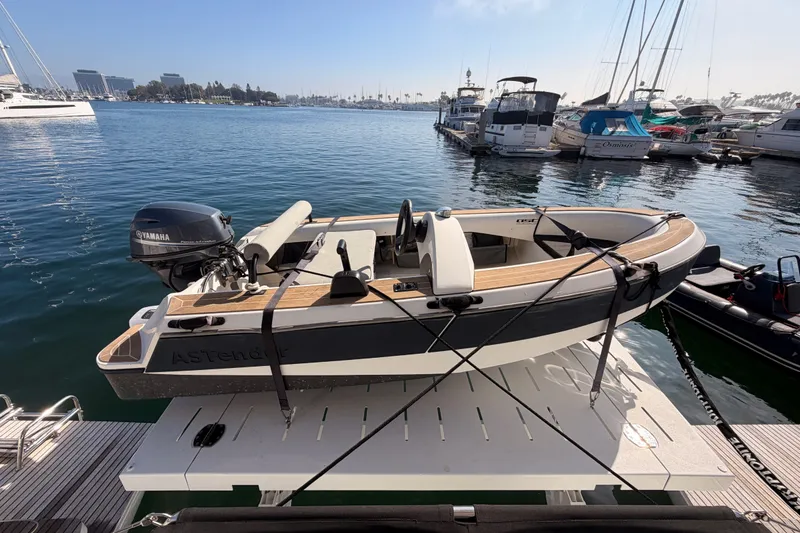 Slide: The Image of Small motorboat docked at marina, featuring Yamaha engine, with Lagoon 42 catamaran in background. - 112
