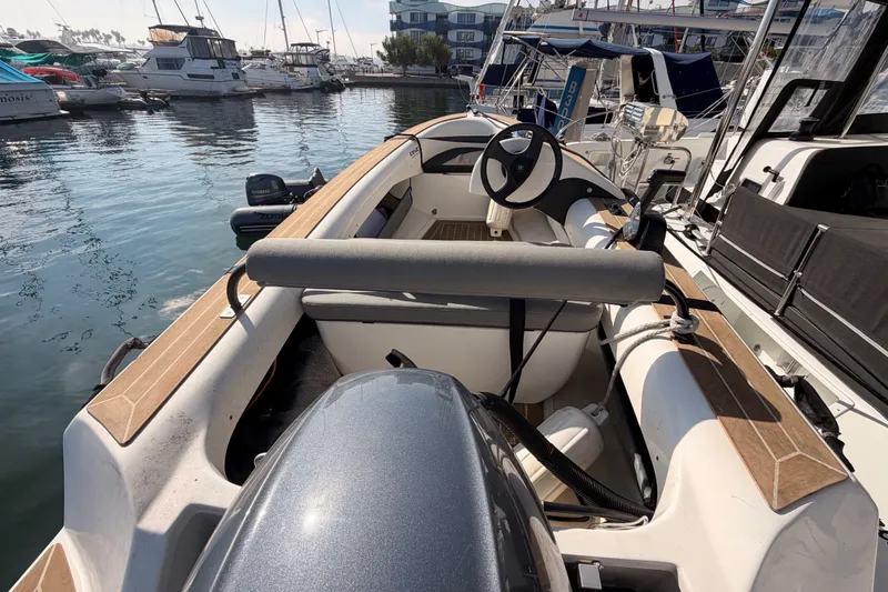 Slide: The Image of A 2020 Lagoon 42 boat docked in a marina, featuring a sleek design and modern steering. - 115