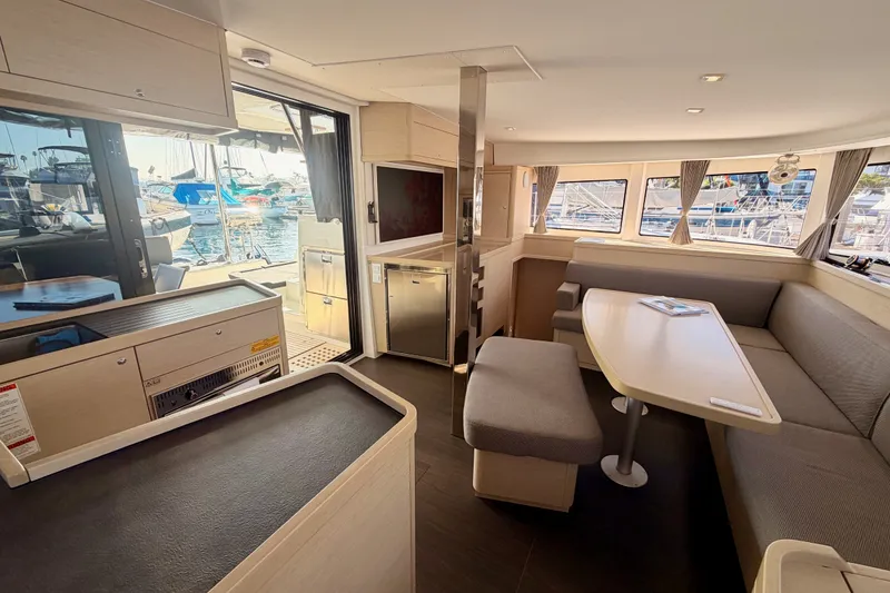 Slide: The Image of Interior of 2020 Lagoon 42 catamaran with modern seating and marina view. - 102