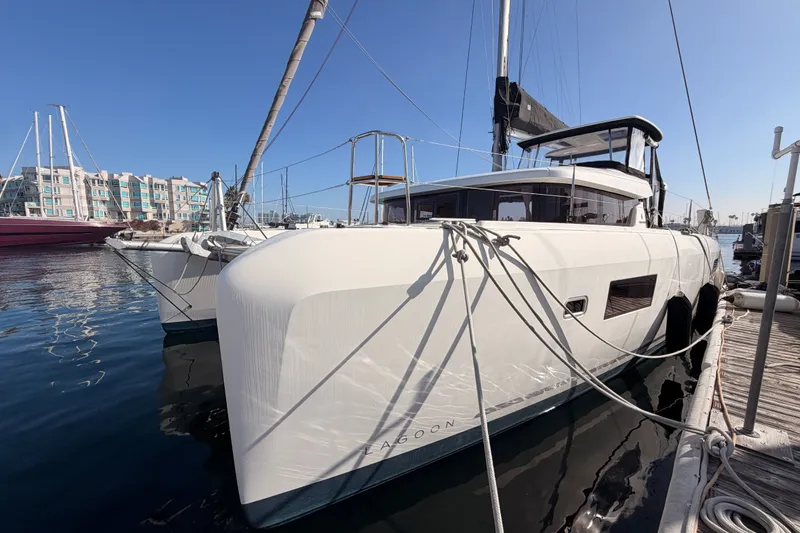 Slide: The Image of 2020 Lagoon 42 catamaran docked at marina, showcasing sleek design and modern features. - 3