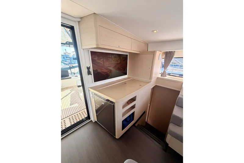 Slide: The Image of Interior of 2020 Lagoon 42 yacht featuring modern kitchenette and scenic window view. - 56