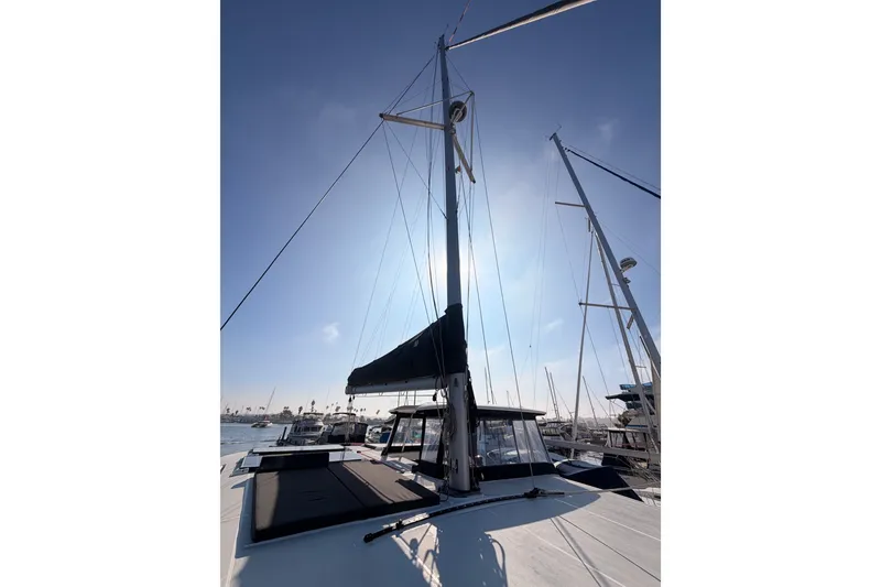 Slide: The Image of 2020 Lagoon 42 catamaran with sails down, docked in a sunny marina. - 23