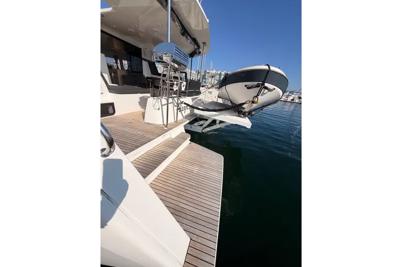 Slide: The Image of Lagoon 42 catamaran (2020) with tender on davits, docked in a sunny marina. - 8